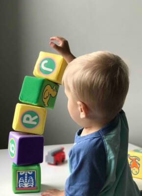A child stacking colourful blocks