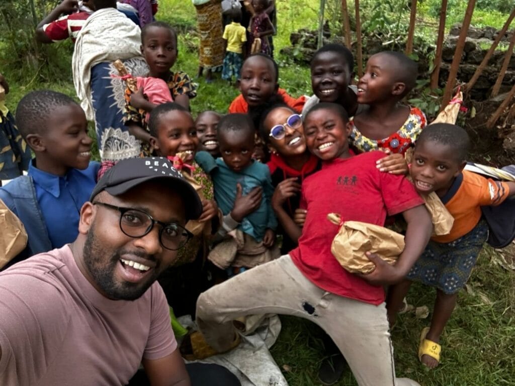 Ein Mann und Kinder posieren gemeinsam unter Bäumen