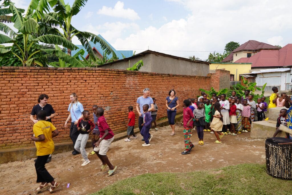 Besucher und Kinder spielen gemeinsam auf einer Wiese