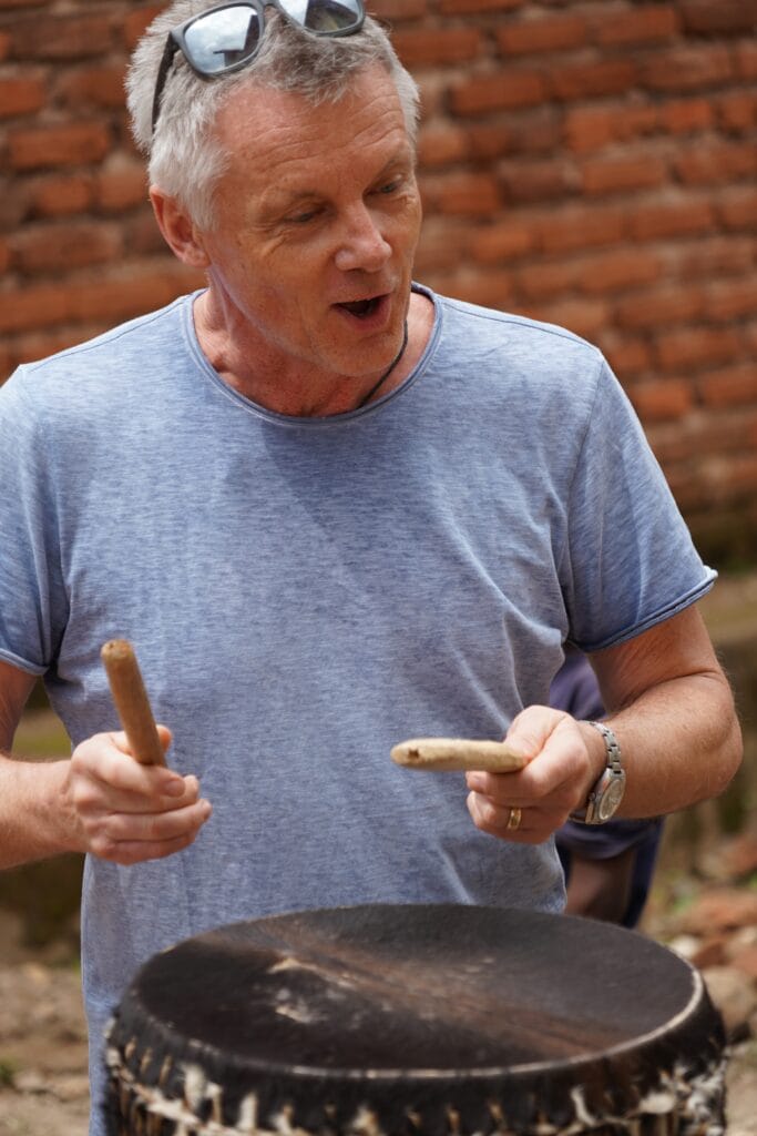 Ein Besucher bereitet Brot über einem großen Topf zu