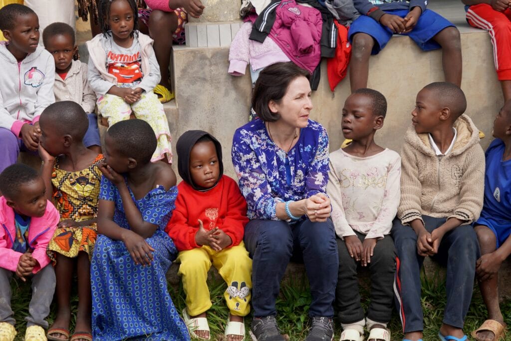 Ein Kind spielt mit einer Erwachsenen zwischen anderen Kindern
