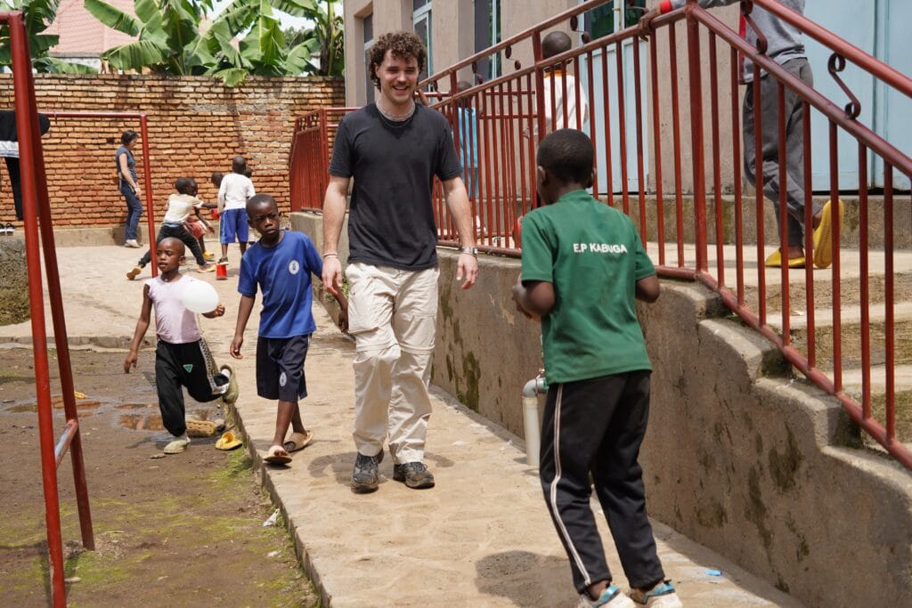 Ein Besucher geht mit Kindern durch einen Hof