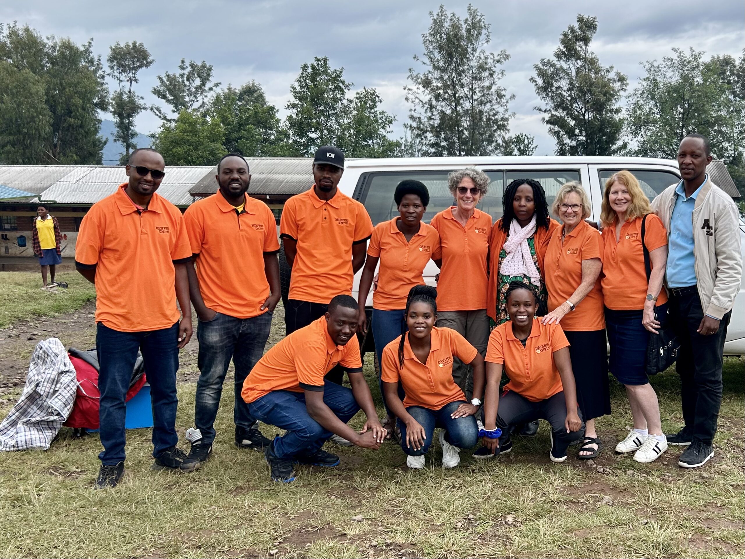 DaysForGirls-Team in orangefarbenen Oberteilen vor einem Gebäude